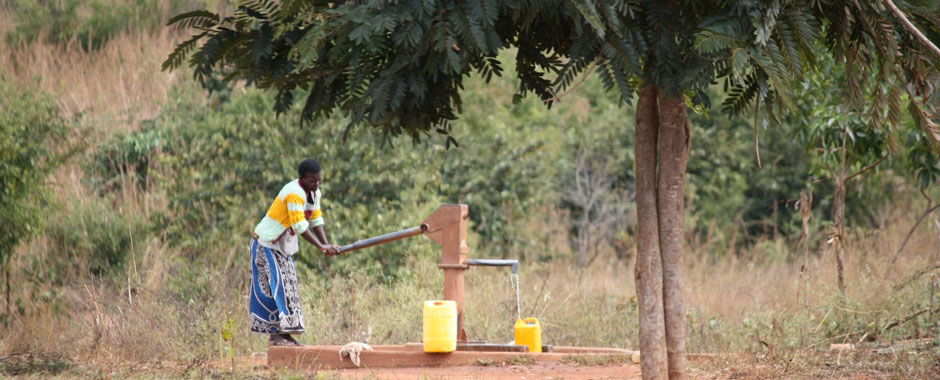 A woman pumps water into a bucket in Mozambique