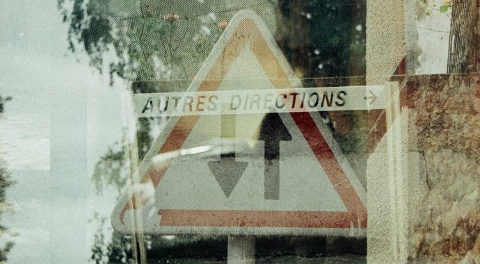 Triple exposure photograph with road sign reading 'Autres Directions'