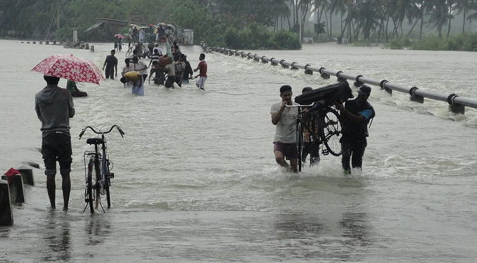 People walking along a flooded causeway