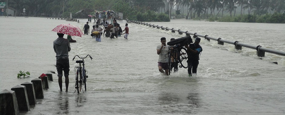 People walking along a flooded causeway