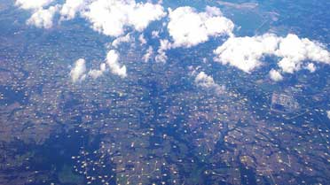 Aerial view of small roads with small pits or lakes taken from a plane.