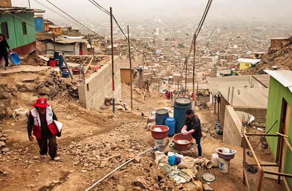 Image of a person climbing a dusty road in San Juan de Lurigancho, a slum on the outskirts of Lima.